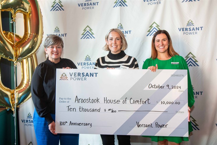 3 women posing with large donation check